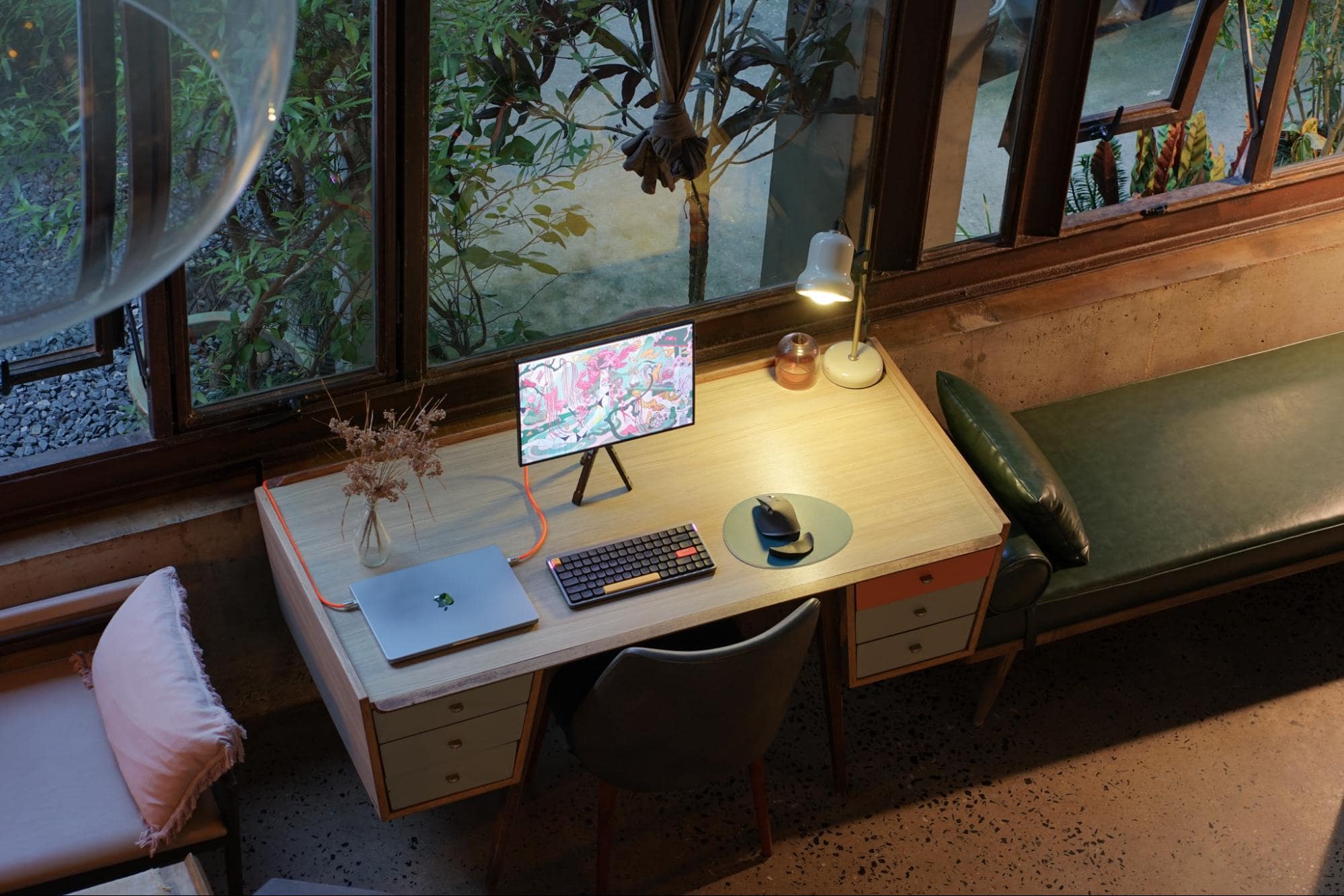  A cosy, compact travel desk setup by a window overlooking greenery