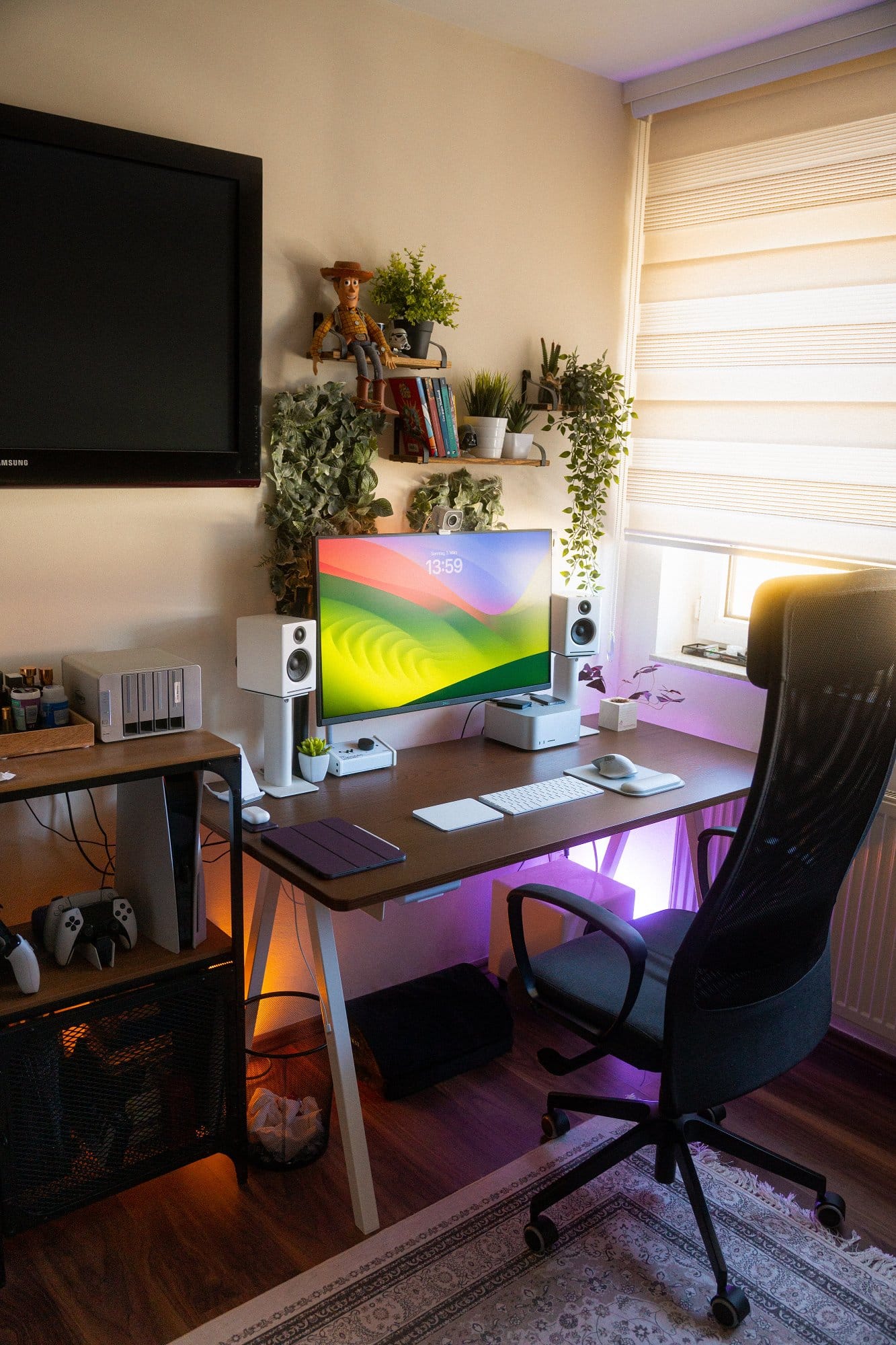  A cosy home office setup with a large computer monitor, a desk with various tech accessories and houseplants