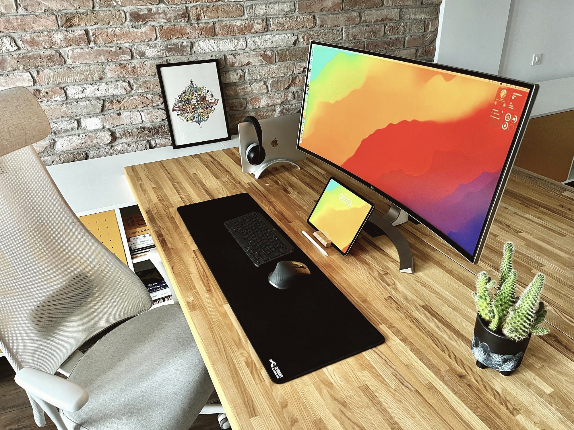 A minimalist home office desk setup with an exposed brick wall