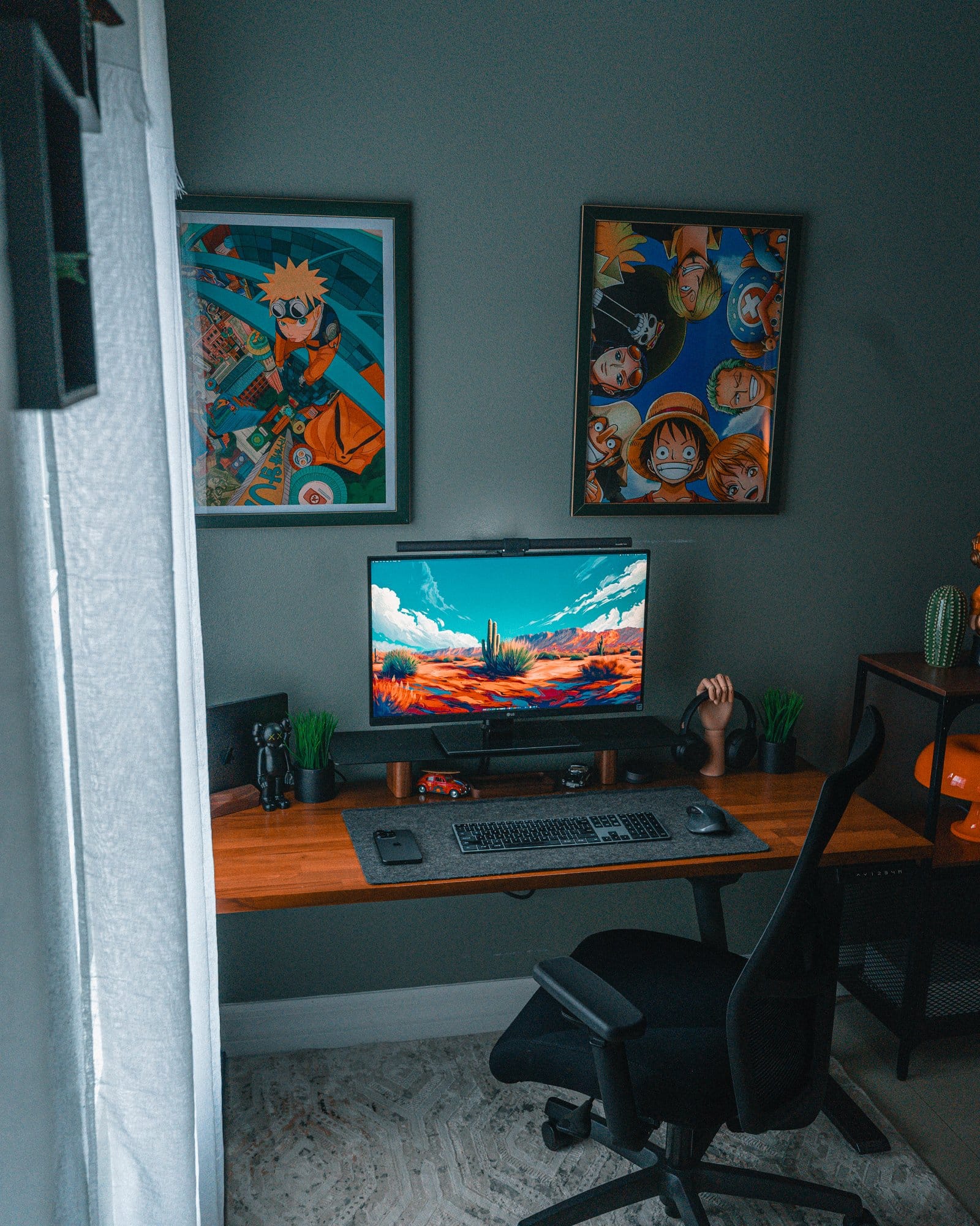  A modern desk setup featuring an LG 27" 27BN88U-B Ergo monitor mounted with its own Ergo mount, a BenQ Halo LightBar on top, a 14" M3 MacBook Pro, Edifier R1700BTS and IKEA VAPPEBY speakers, Edifier W820NB headphones, a Satechi Slim X3 keyboard, a Logitech MX Master 2S mouse, and a Hexcal desk mat, complemented by anime posters of Naruto and One Piece on the wall