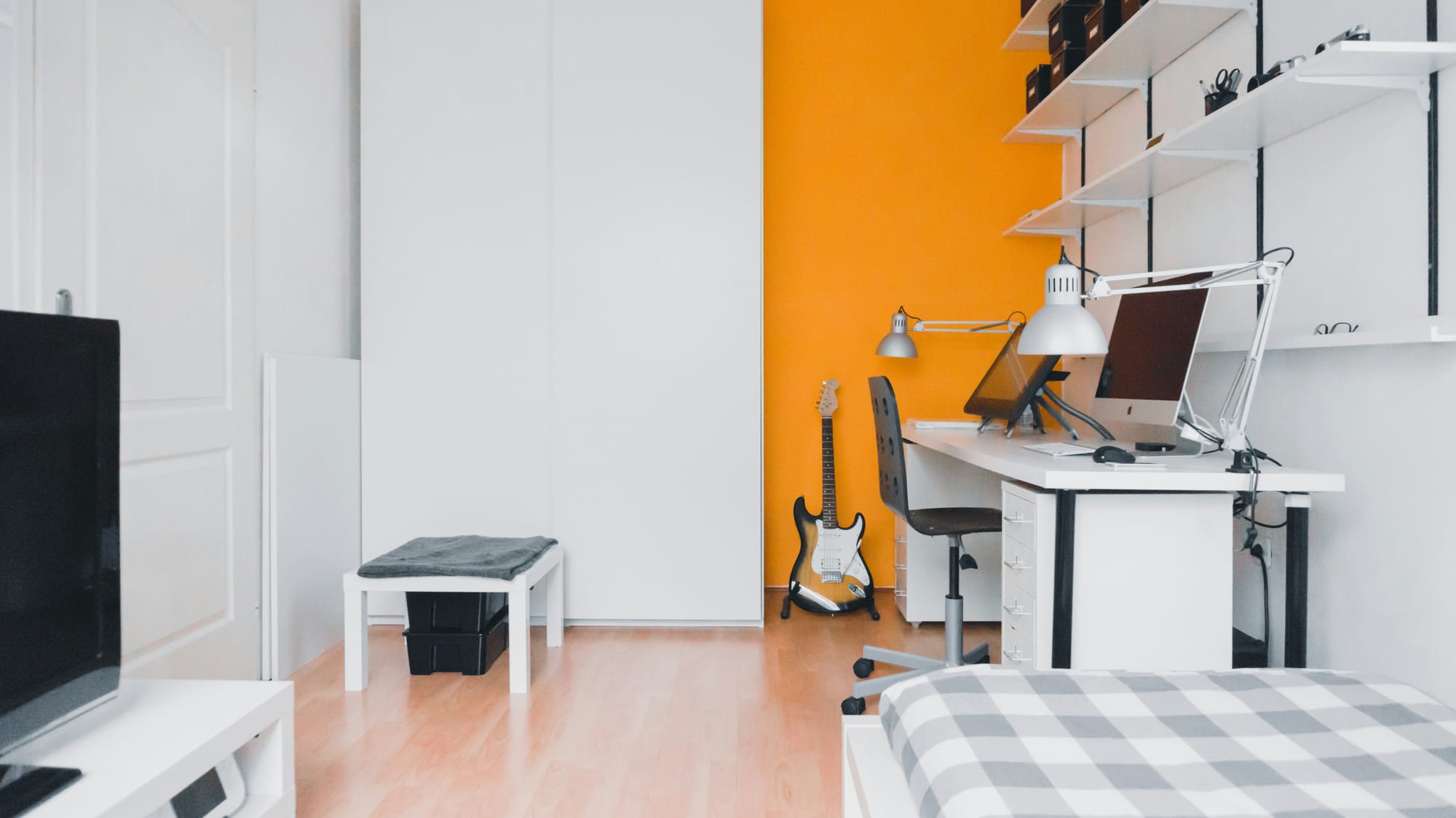 A home office with an orang accent wall