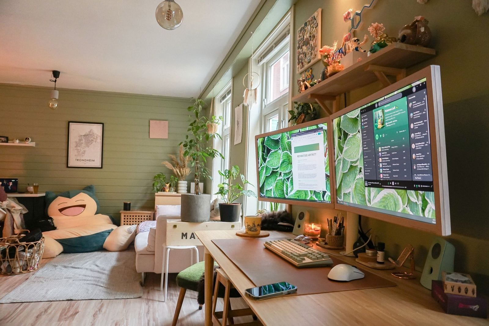 A zen-like home office with two monitors, a giant Snorlax beanbag, and lots of plants