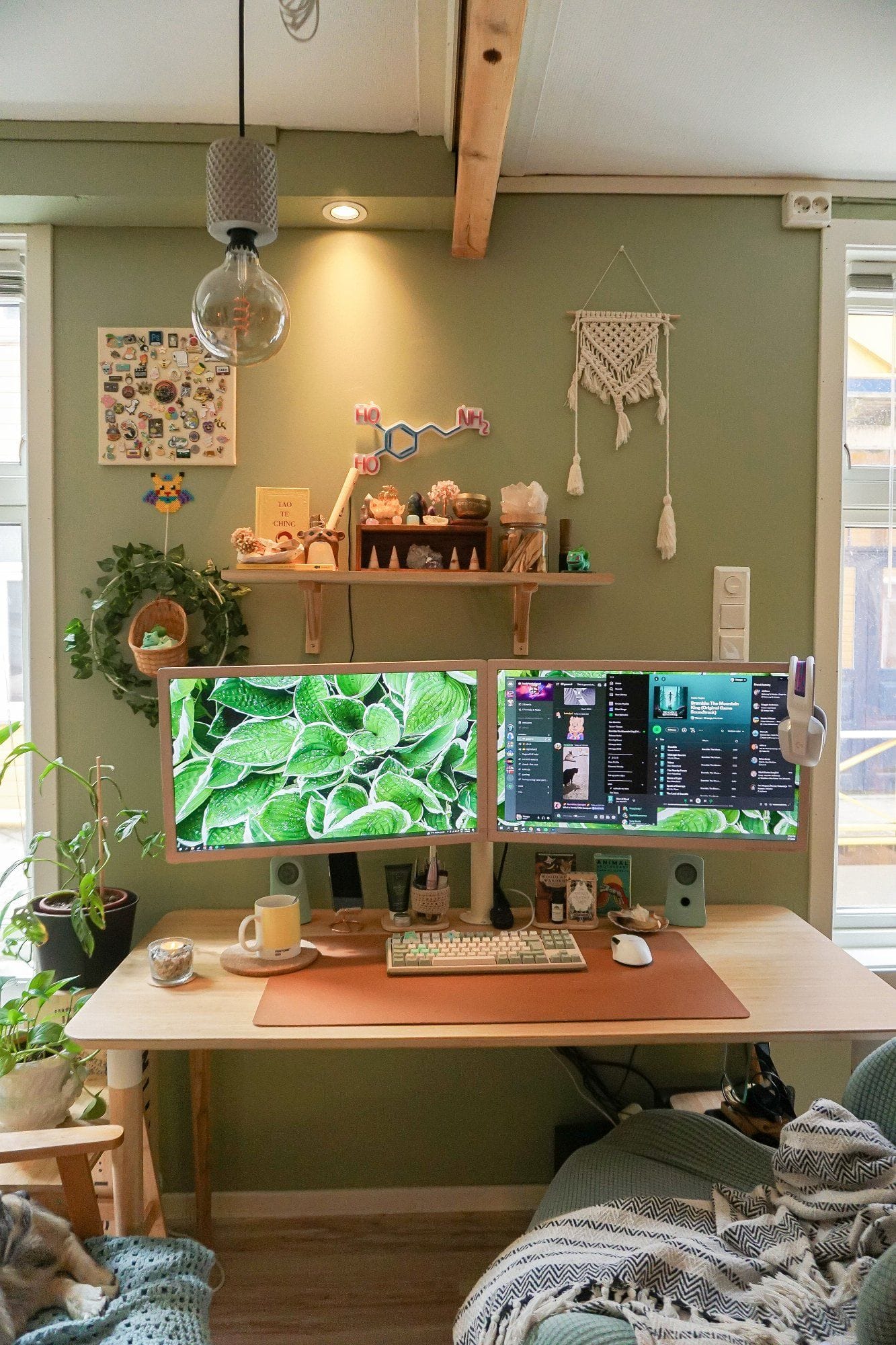A calming green home office with a desk setup featuring two monitors