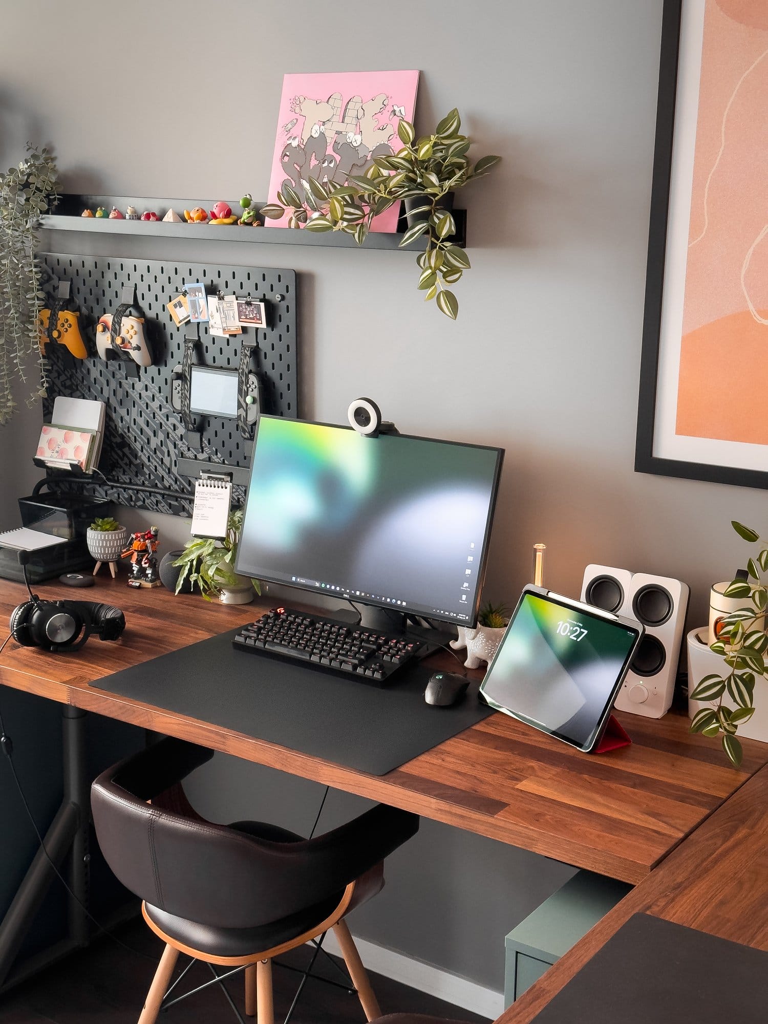  An L-shaped desk setup featuring a Dell monitor with a Razer Kiyo webcam, Logitech G Pro keyboard and mouse, an iPad Pro 12.9 (3rd Gen), Logitech G Pro X headphones, and various plants and decorative items on a wooden IKEA KARLBY desk with IKEA ALEX drawers and an IKEA UPPSPEL pegboard in the background