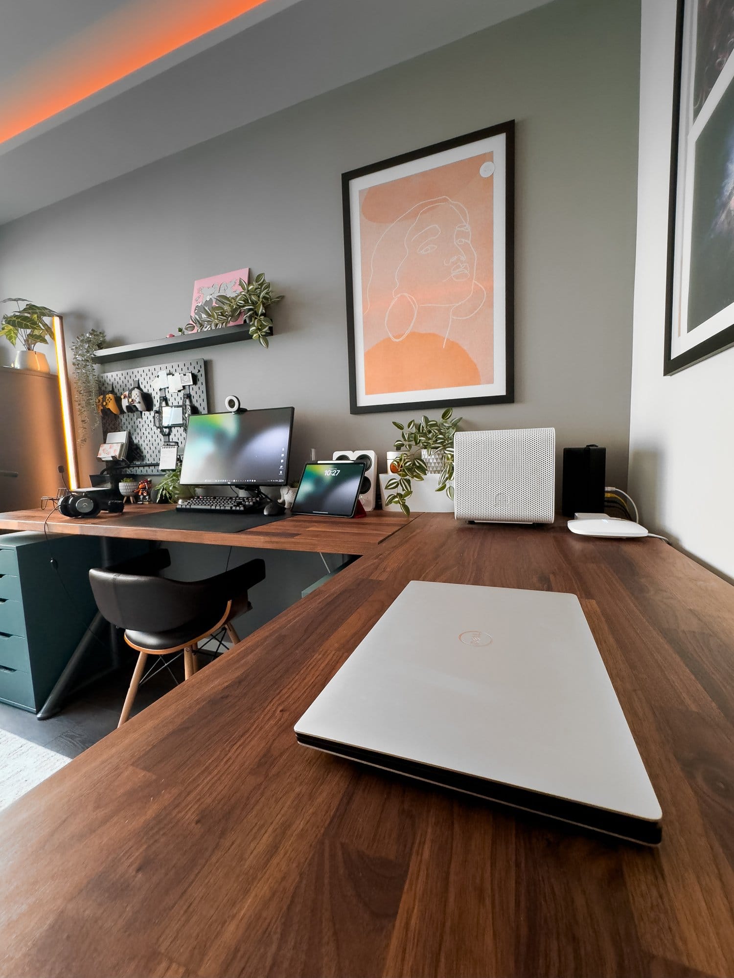 A modern home office setup featuring a Dell XPS 15 9570 laptop on a wooden IKEA KARLBY desk, with a Dell monitor, Razer Kiyo webcam, Logitech G Pro keyboard and mouse, an iPad Pro 12.9 (3rd Gen), and Logitech G Pro X headphones, complemented by plants and framed artwork on the walls