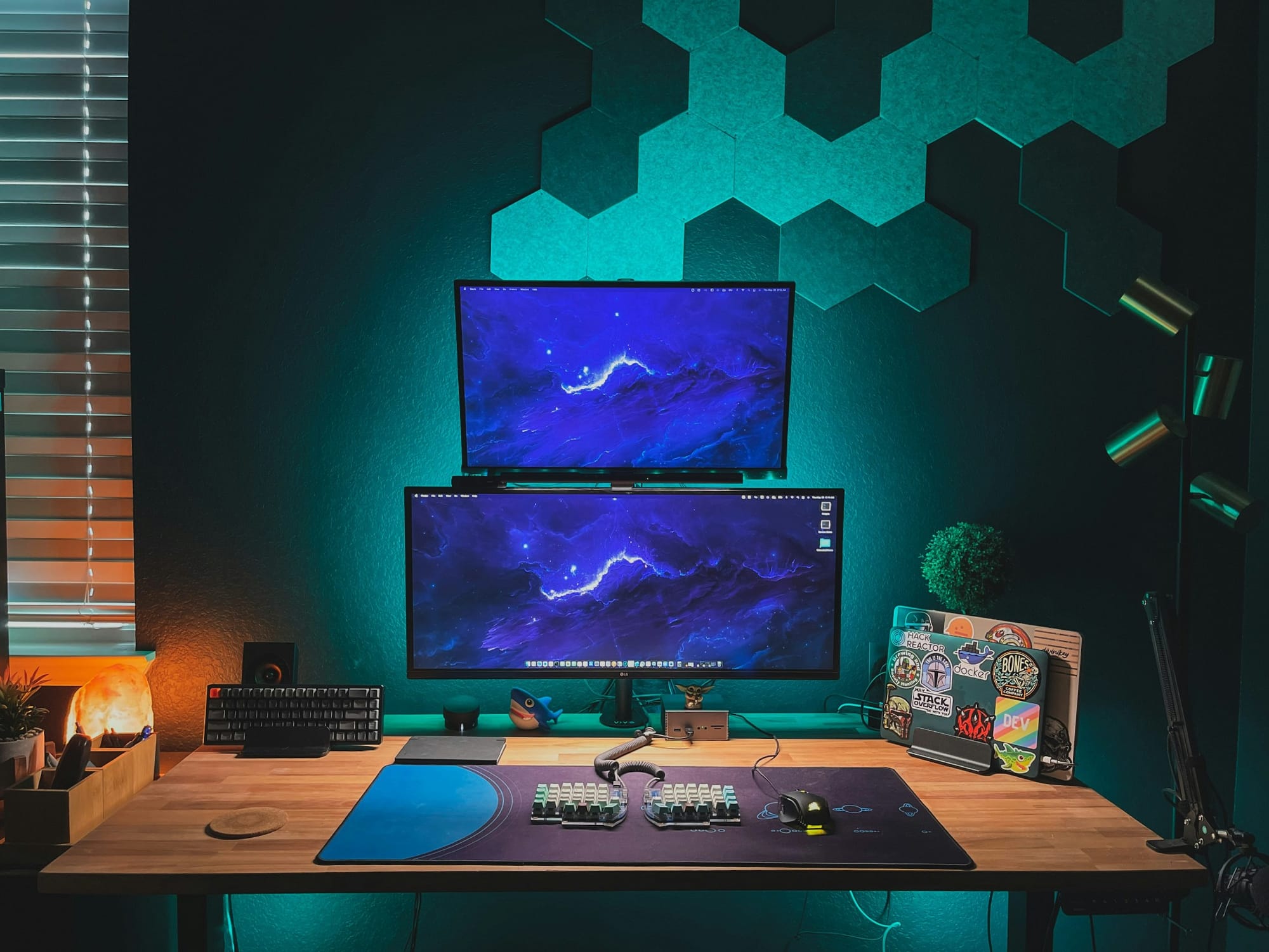 A modern home office setup with dual monitors, backlit by ambient lighting creating a futuristic atmosphere