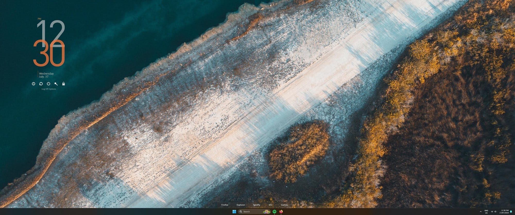 A minimalistic desktop setup featuring a serene aerial landscape wallpaper, with a clean and organised taskbar showing essential applications like Firefox, Explorer, and Spotify