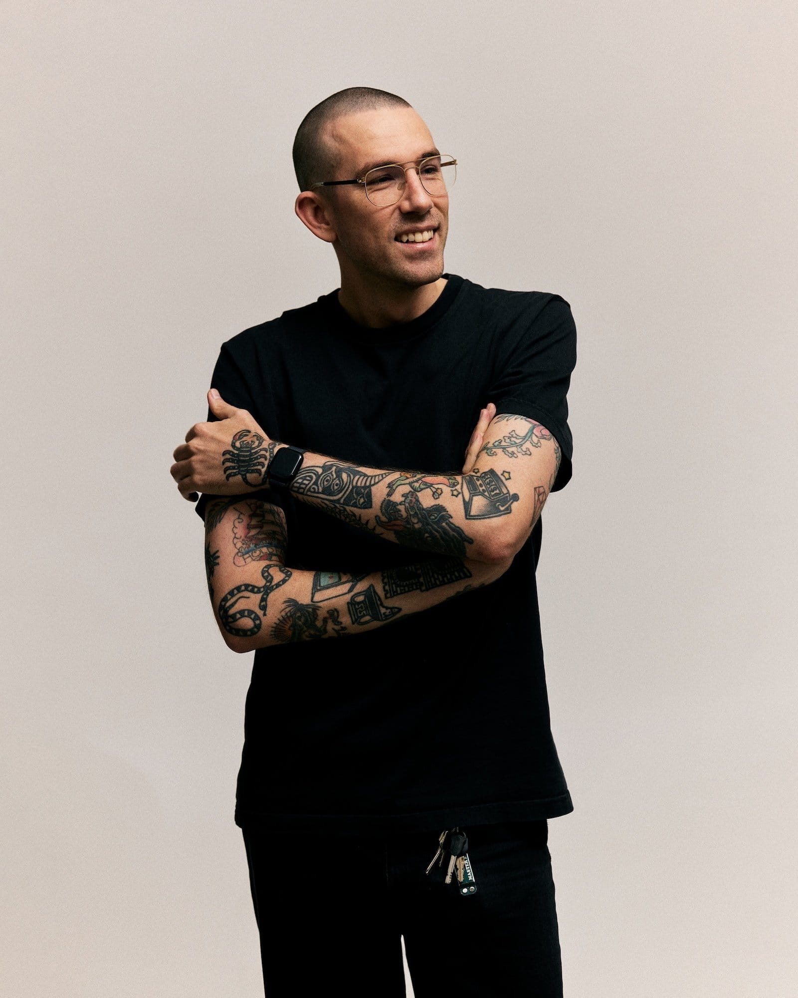 A portrait of Nicholas Christowitz, a Berlin-based digital designer, showcasing his tattooed arms