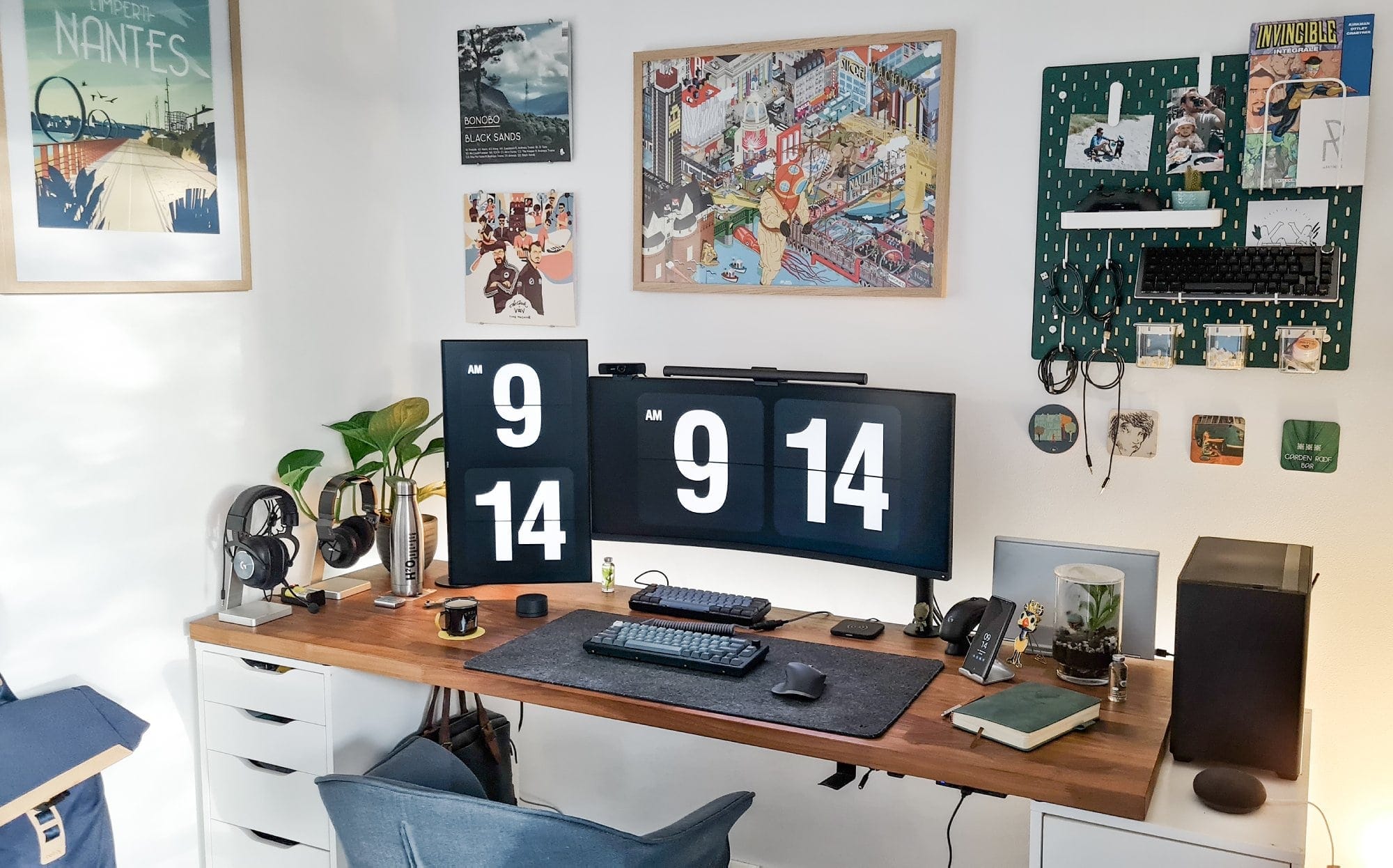 A well-organised desk setup featuring dual monitors on an IKEA KARLBY worktop with ALEX drawers, a mechanical keyboard, and wall-mounted artwork