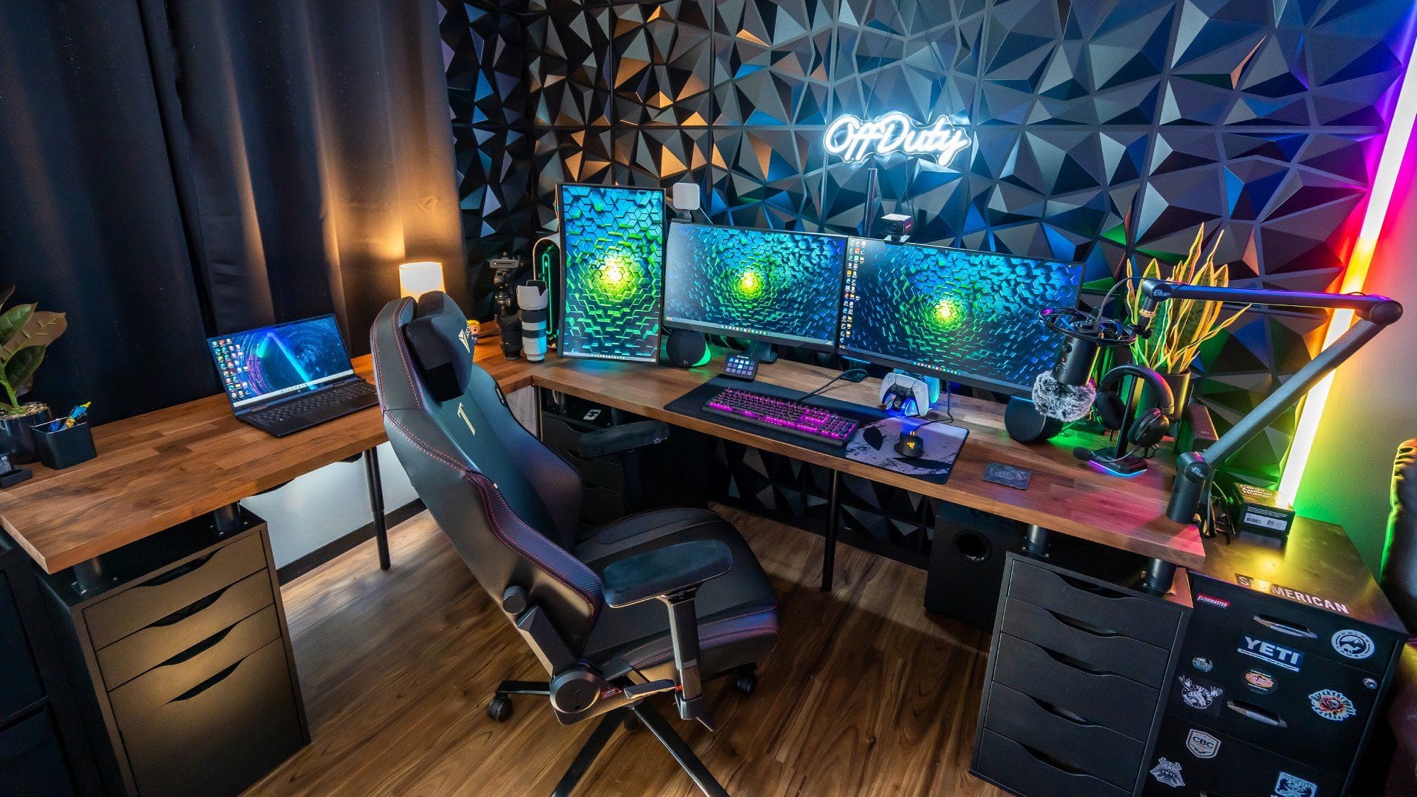 A gaming setup with a vibrant RGB lighting backdrop, featuring a triple monitor arrangement on an IKEA KARLBY worktop supported by ALEX drawers