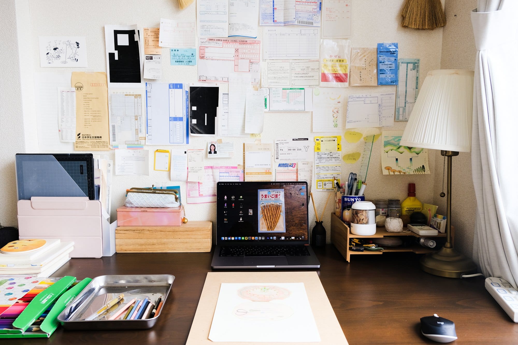  A laptop-only desk setup in a small apartment with a 2021 MacBook Pro, a MUJI wooden letter tray, and an IKEA ÅRSTID lamp