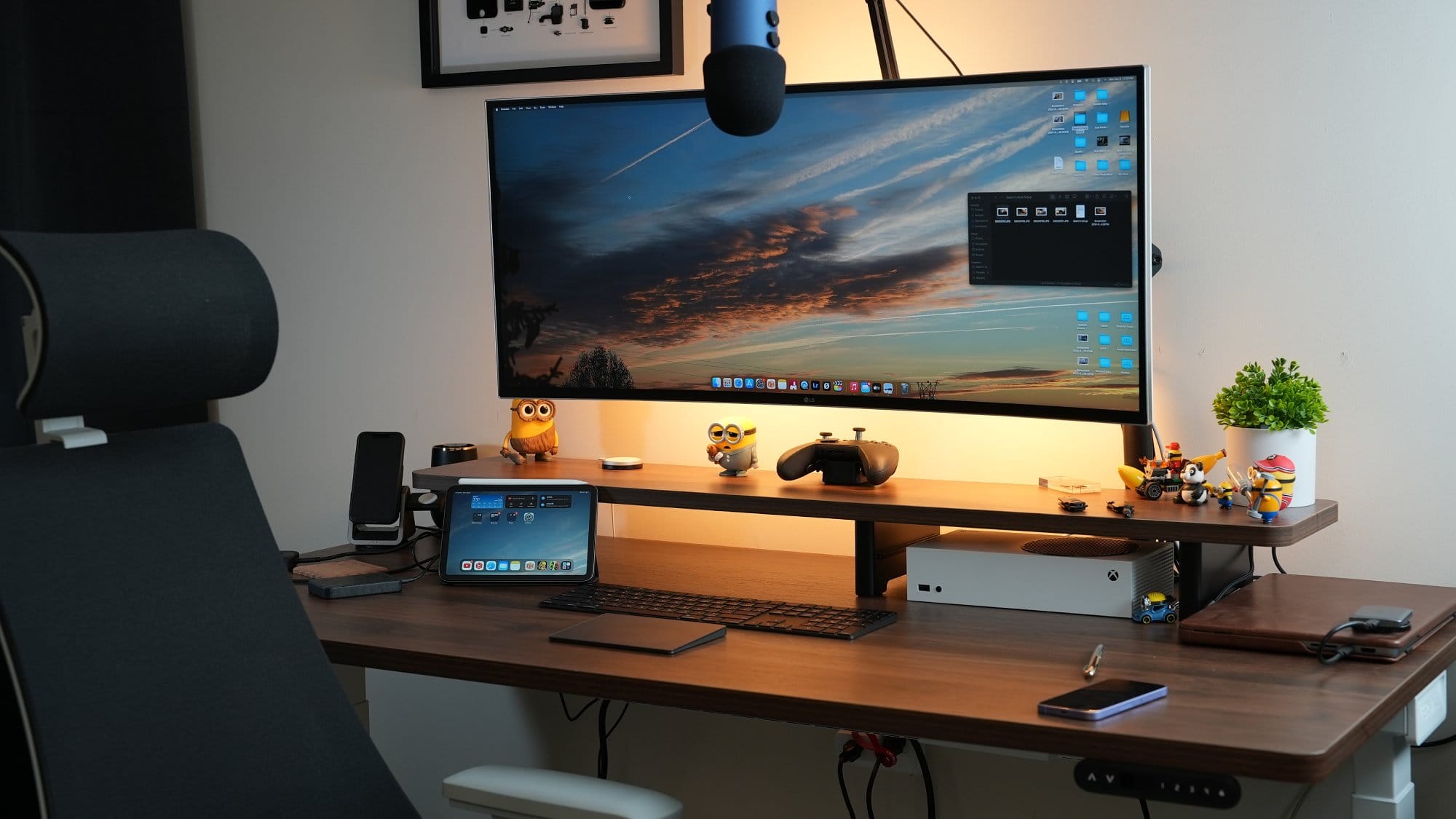 A home office setup with an LG 38WN95C-W monitor on a Vivo Arm, a MacBook Pro, and an Xbox Series S on a Vernal desk shelf