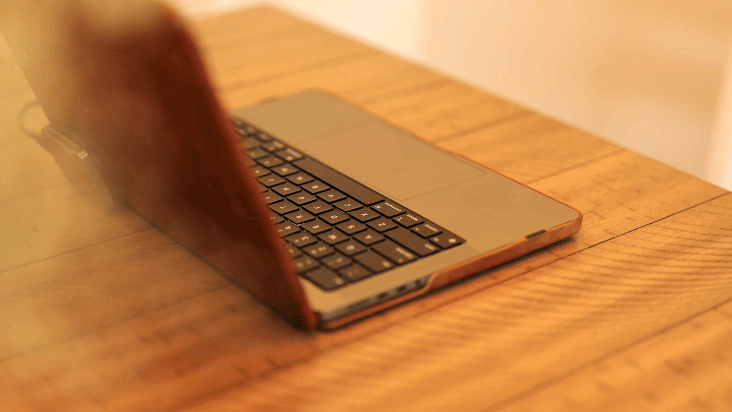 A close-up of a MacBook Pro on a wooden table