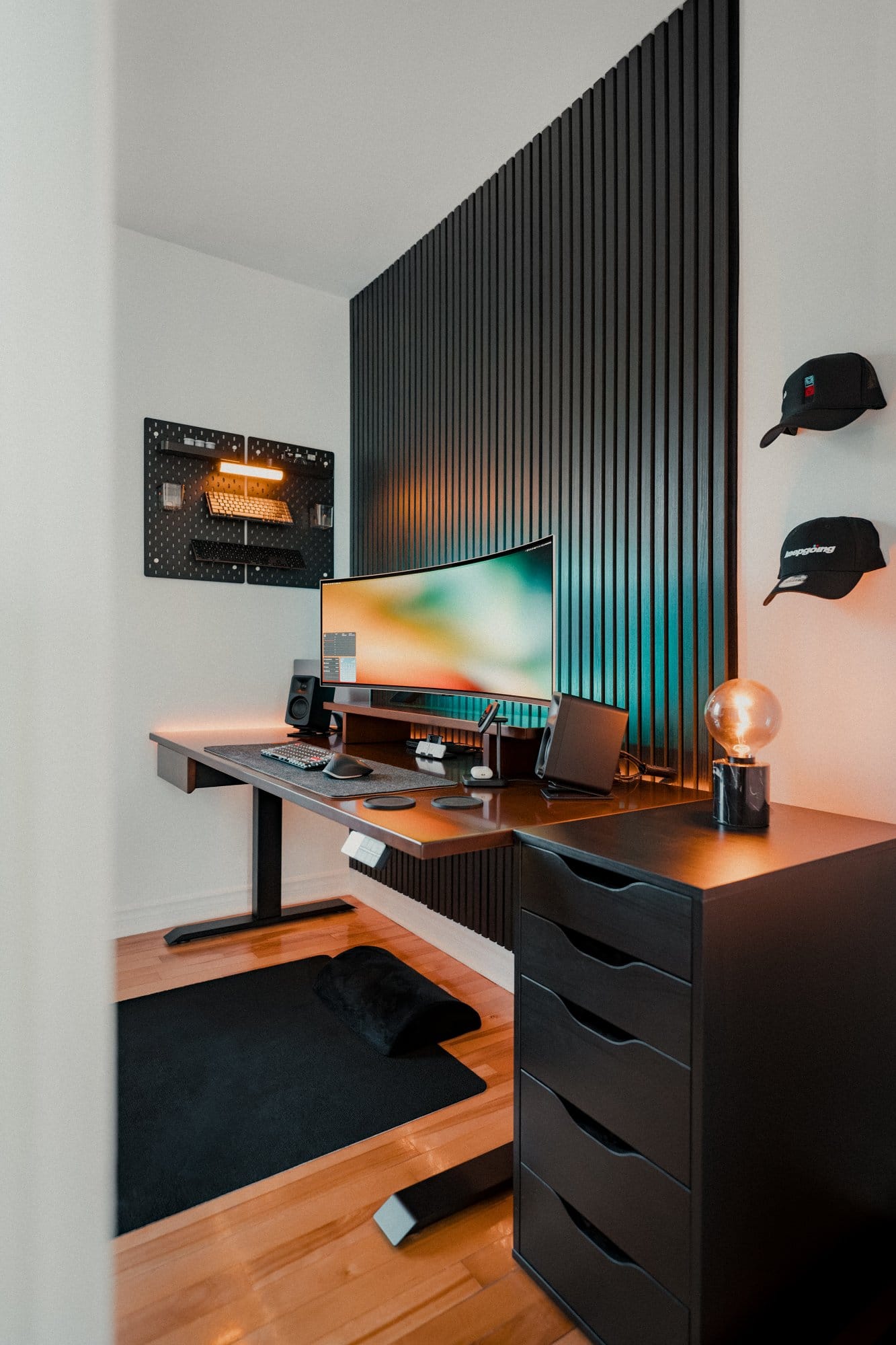 A home office setup with a Samsung 49″ Odyssey OLED G9 monitor on a Desky Dual Motor Sit-Stand Desk, Keychron K3 Pro keyboard, Kanto ORA Reference Desktop Speakers, an IKEA SKÅDIS pegboard on the wall, and a set of drawers to the side