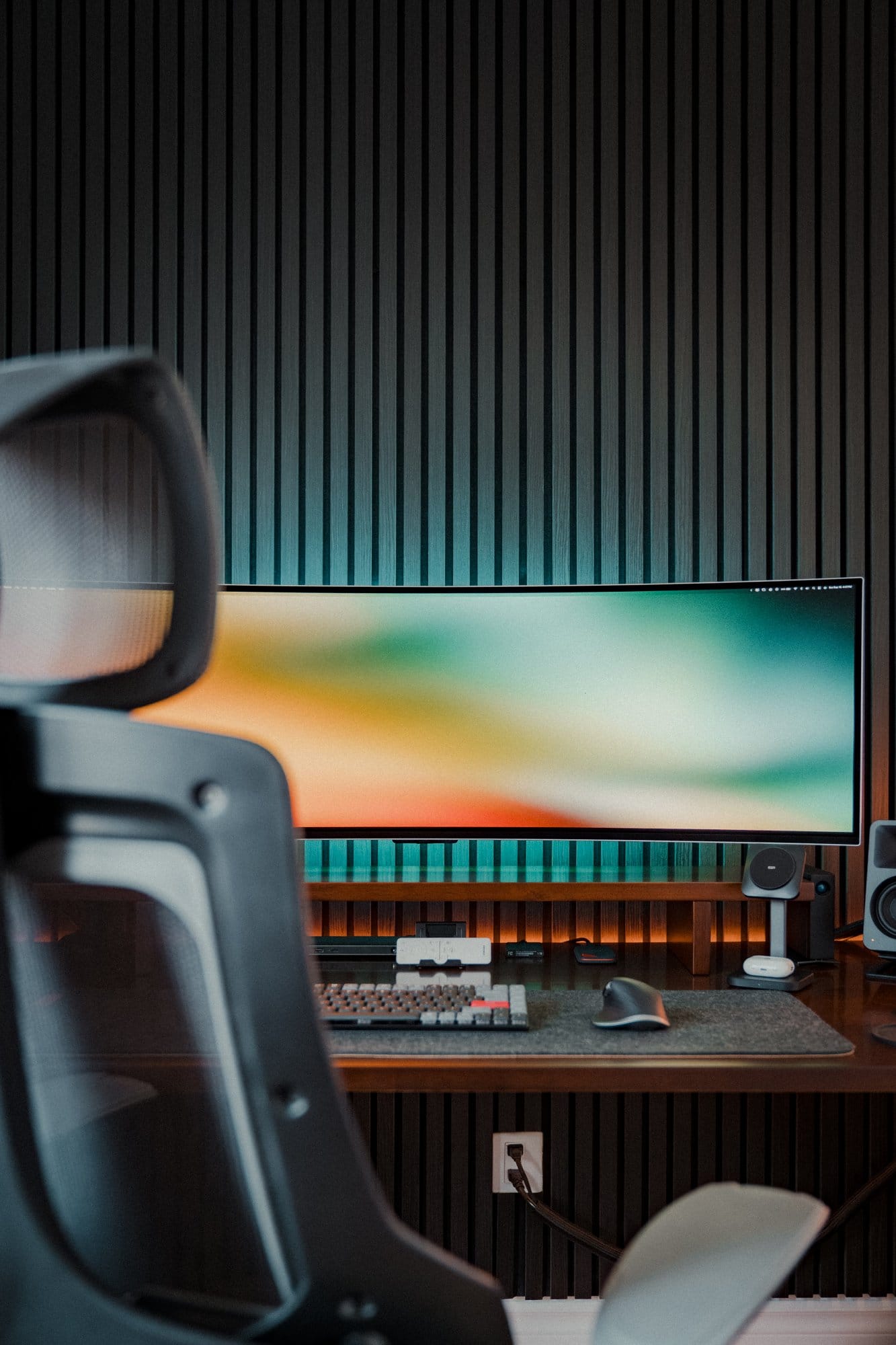 A dark desk setup showing a Samsung 49″ Odyssey OLED G9 monitor, Keychron K3 Pro keyboard, Desky Pro+ ergonomic chair, and Govee LED lights behind the monitor