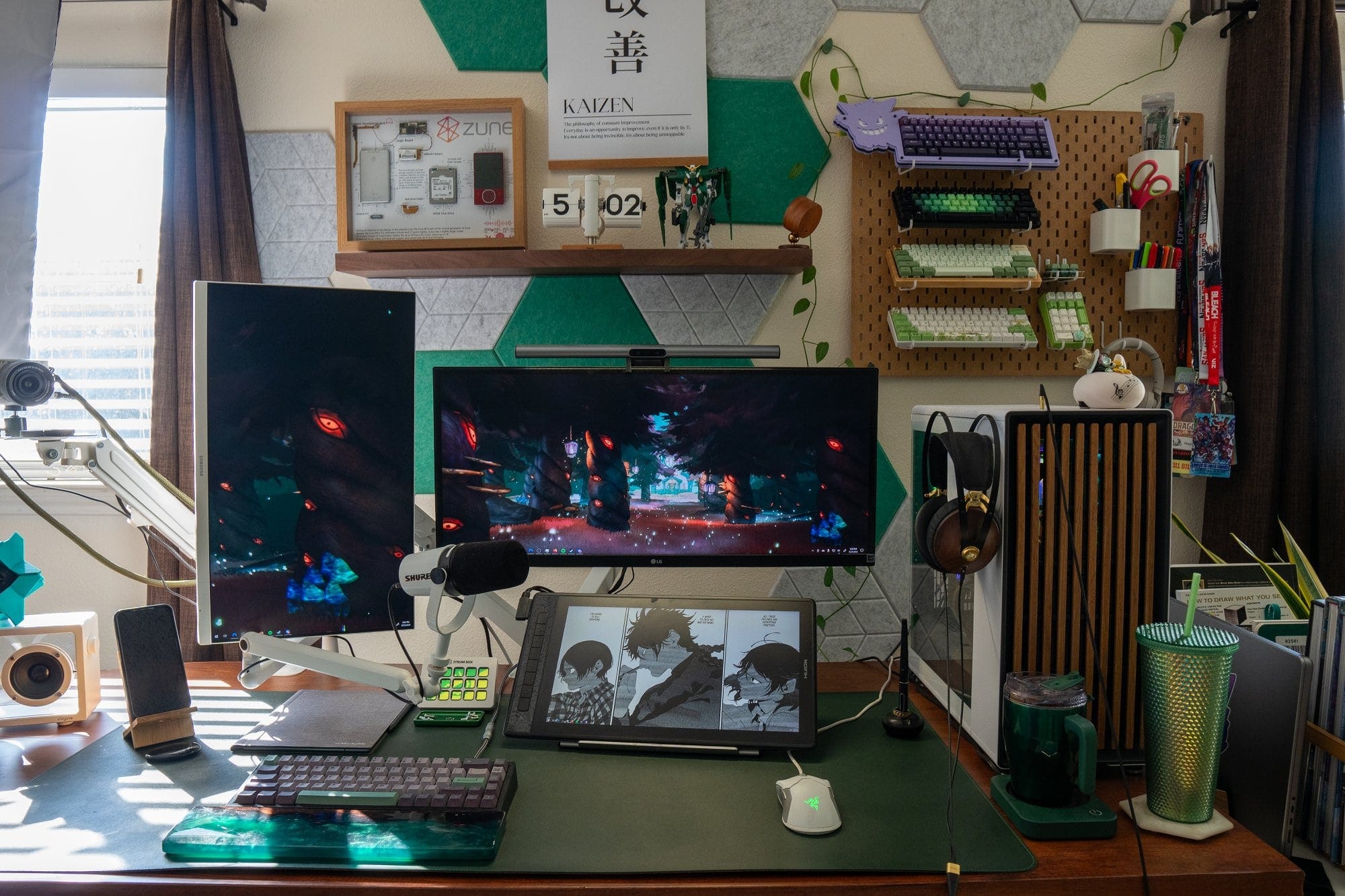 A multi-monitor desk setup with headphones hanging beside a desktop PC and a pegboard holding several mechanical keyboards