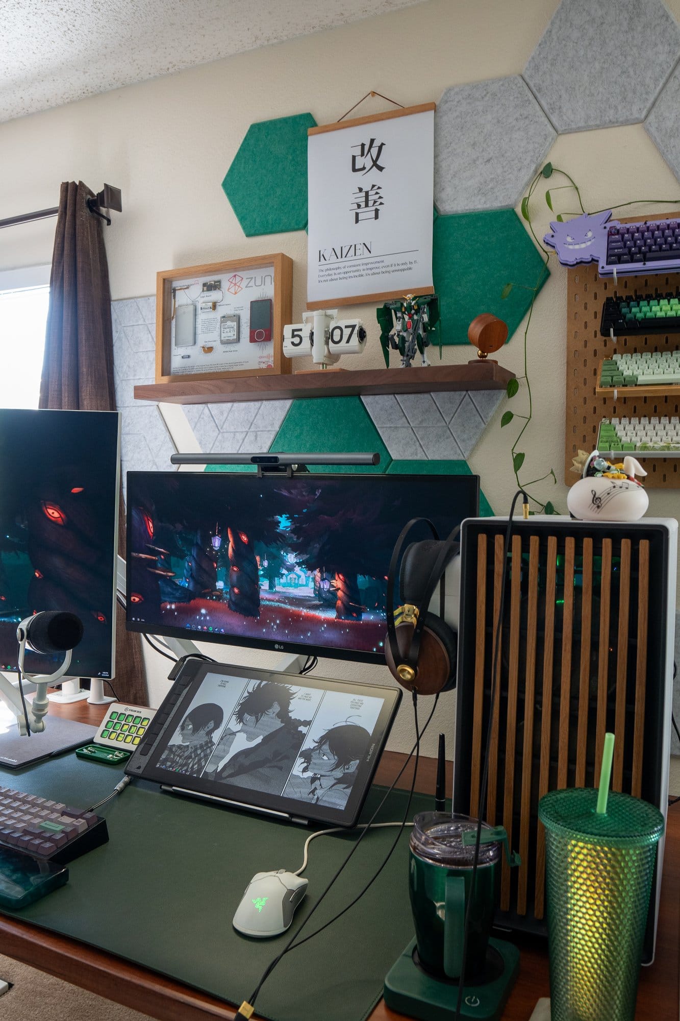 A desk setup with an LG Ultrawide monitor, a HUION KAMVAS Pro 16 drawing tablet, a Razer Viper Ultralight mouse on a dark green leather desk pad, Meze 99 Classics headphones hanging beside a GIGABYTE GeForce RTX 3070 Ti, and a Stream Deck placed next to a mechanical keyboard