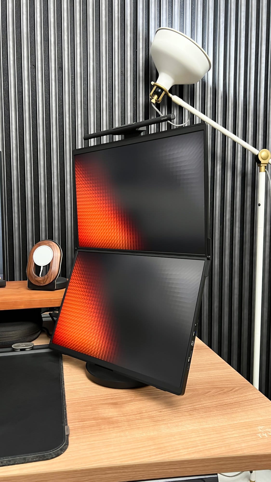 A JSAUX FlipGo dual-screen portable monitor setup on a Tyyli standing desk, with a task lamp mounted above and a Reforma acoustic panel as the backdrop