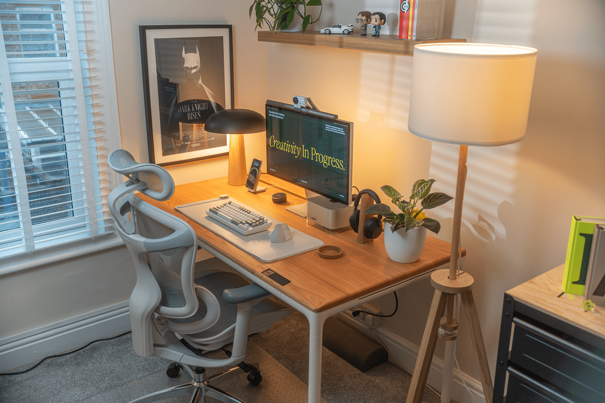 A desk setup with an Apple Studio Display, BenQ Halo monitor light bar, Keychron Q1 Max keyboard, and Logitech Lift mouse on a Beflo Tenon red oak desk, with a Sihoo Doro C-300 chair and a Batman poster by Olly Moss in the background