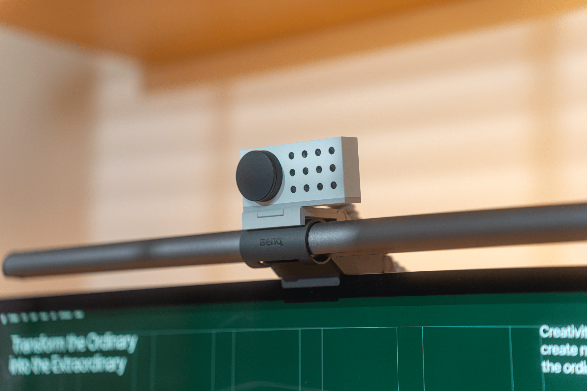 A close-up of a BenQ monitor light bar with an Opal C1 webcam mounted on top of a monitor