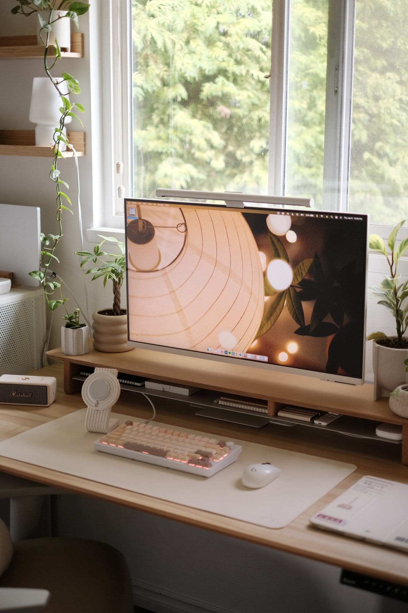 A workspace by a window with a Samsung monitor, a Keychron Q1 V2 keyboard, and a Logitech G305 mouse on a beige desk mat