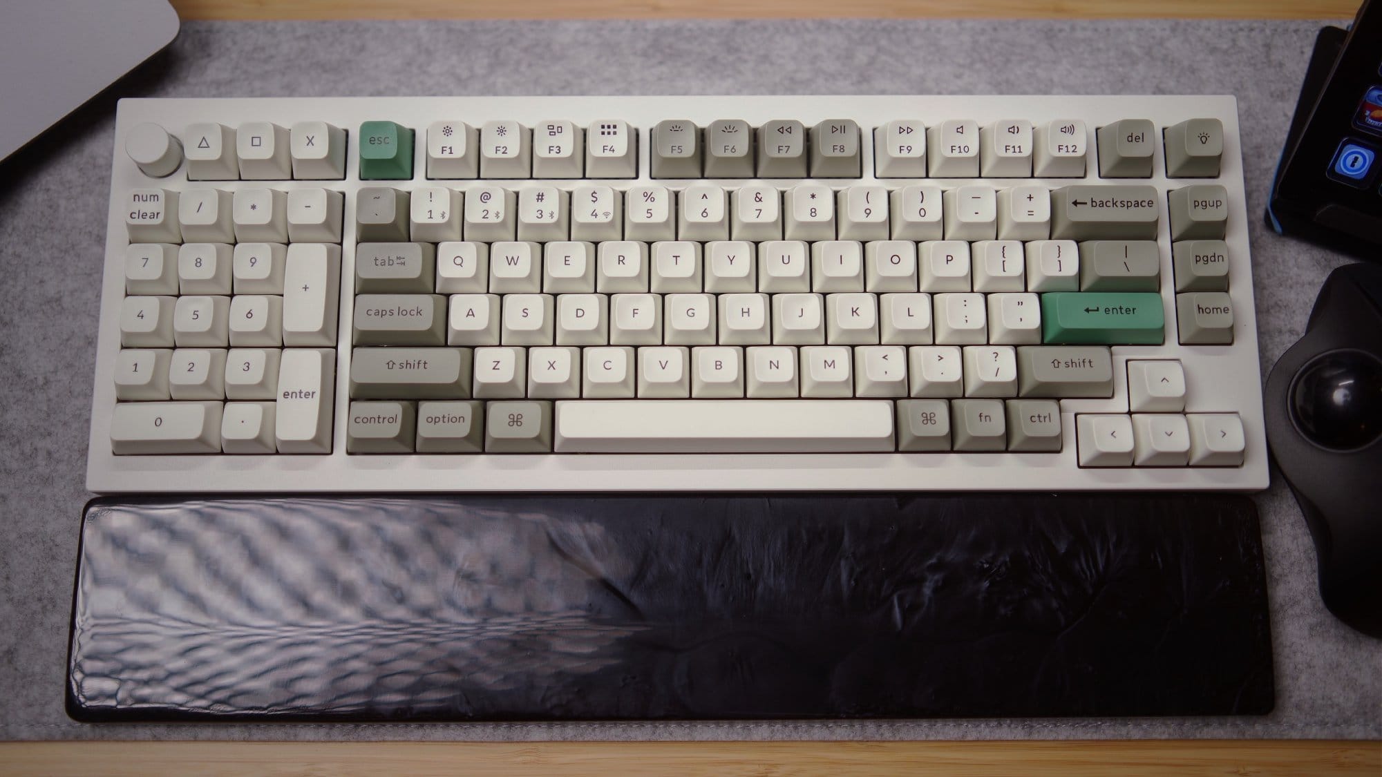 A top-down view of a Keychron Q12 Max mechanical keyboard with a wrist rest on a DeltaHub felt desk mat