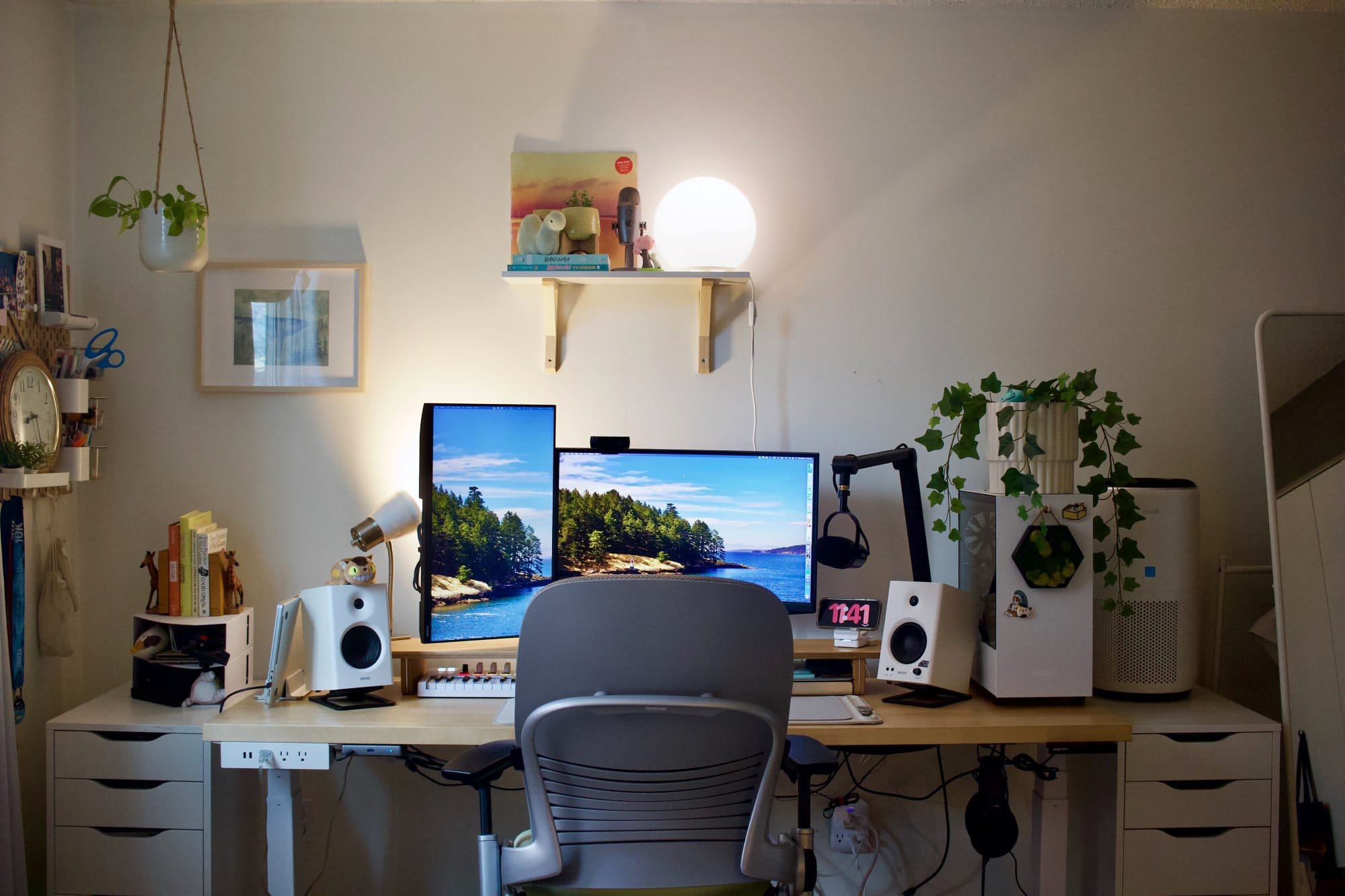 A workspace setup with a Samsung Odyssey G5 main monitor, a Samsung 24″ FHD vertical monitor, a Shure MV7 microphone on a Blue Compass Boom Arm, Edifier MR4 speakers, a Steelcase Leap V2 chair, and a custom PC with a potted plant on top