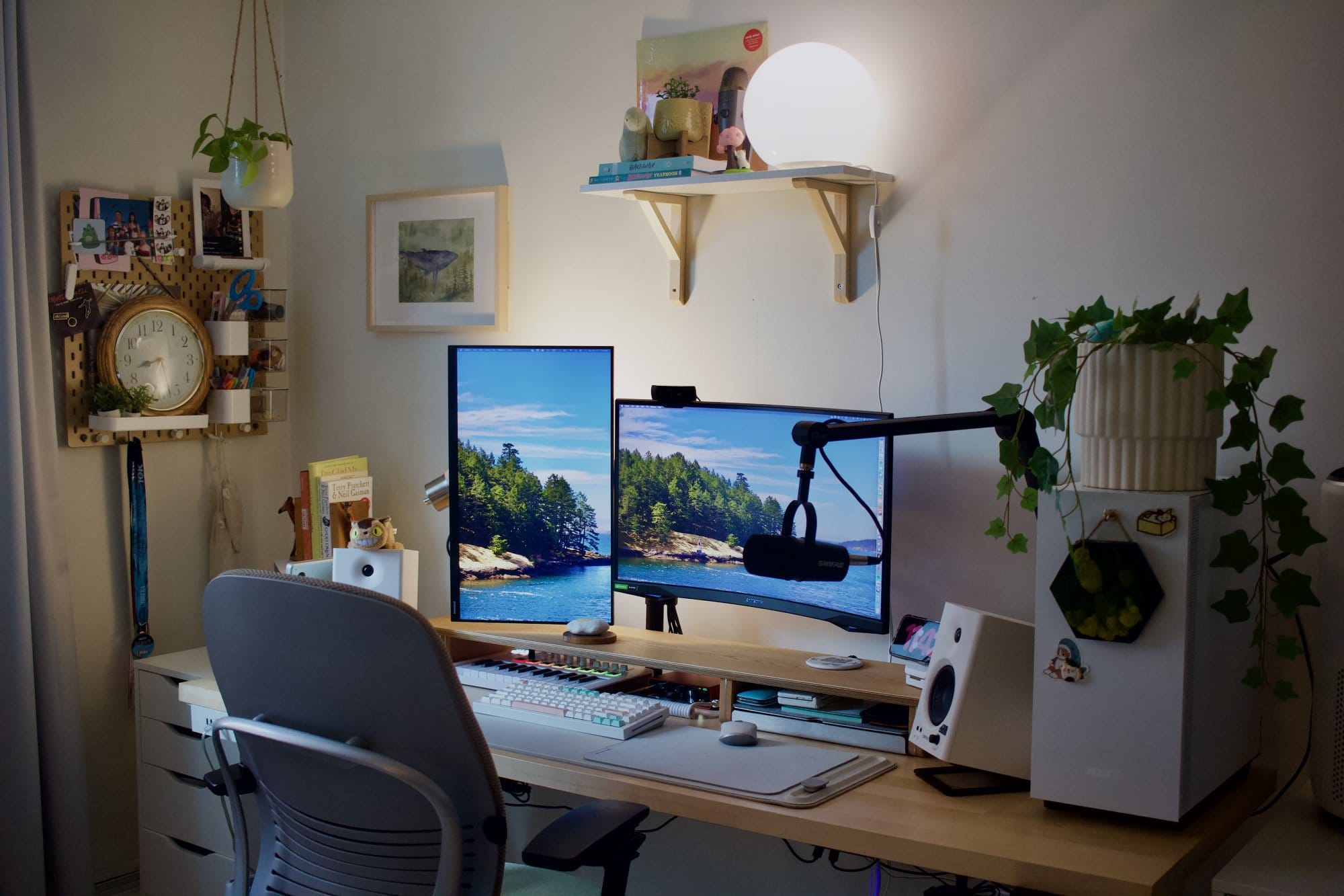 A workspace setup with a Samsung Odyssey G5 main monitor, a Samsung 24″ FHD vertical monitor, a Shure MV7 microphone on a Blue Compass Boom Arm, Edifier MR4 speakers, a Steelcase Leap V2 chair, and a custom PC with a potted plant on top