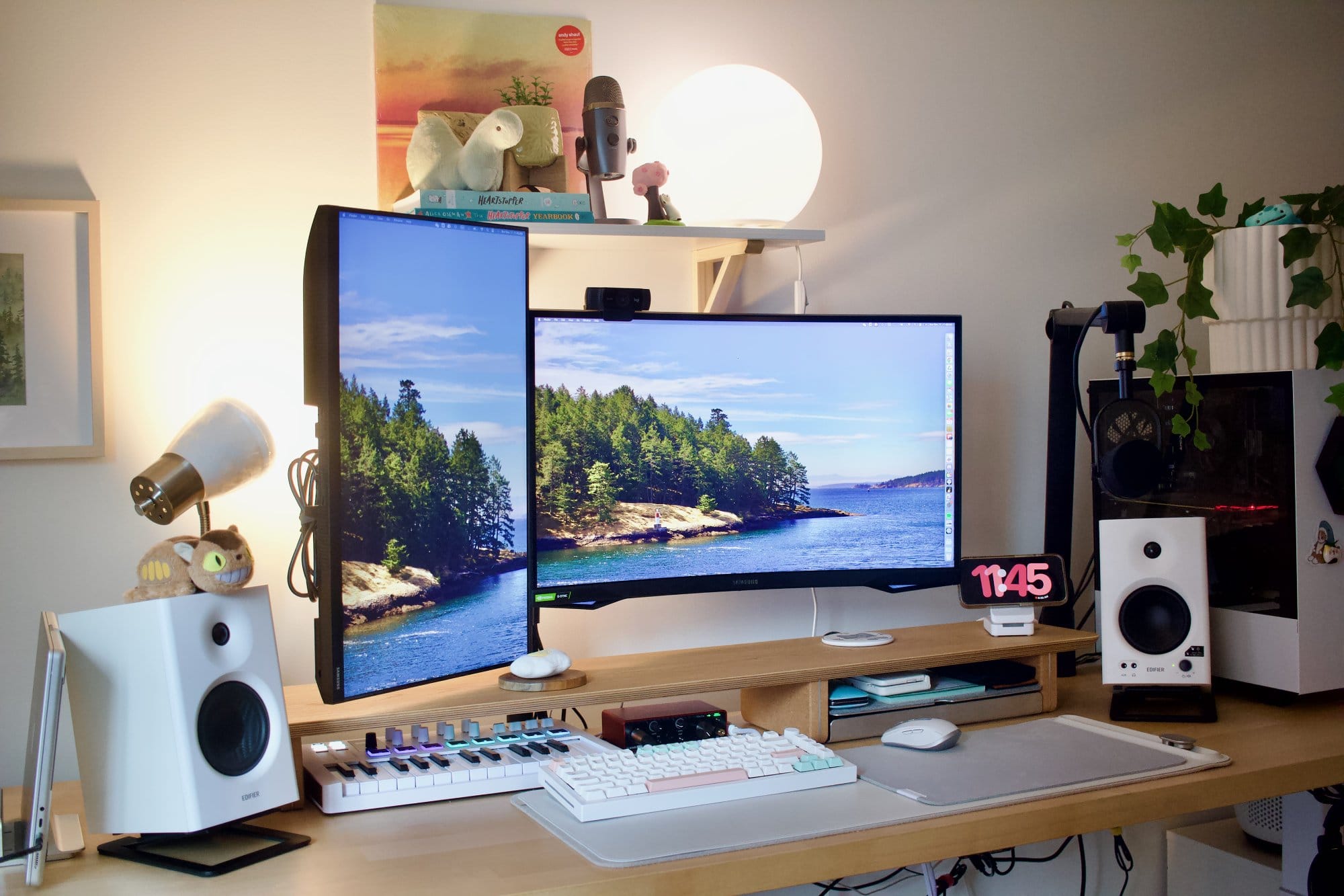 A workspace setup with a Samsung Odyssey G5 main monitor, a Samsung 24″ FHD vertical monitor, a Shure MV7 microphone on a Blue Compass Boom Arm, a GMMK Pro keyboard, and a custom PC with a potted plant on top