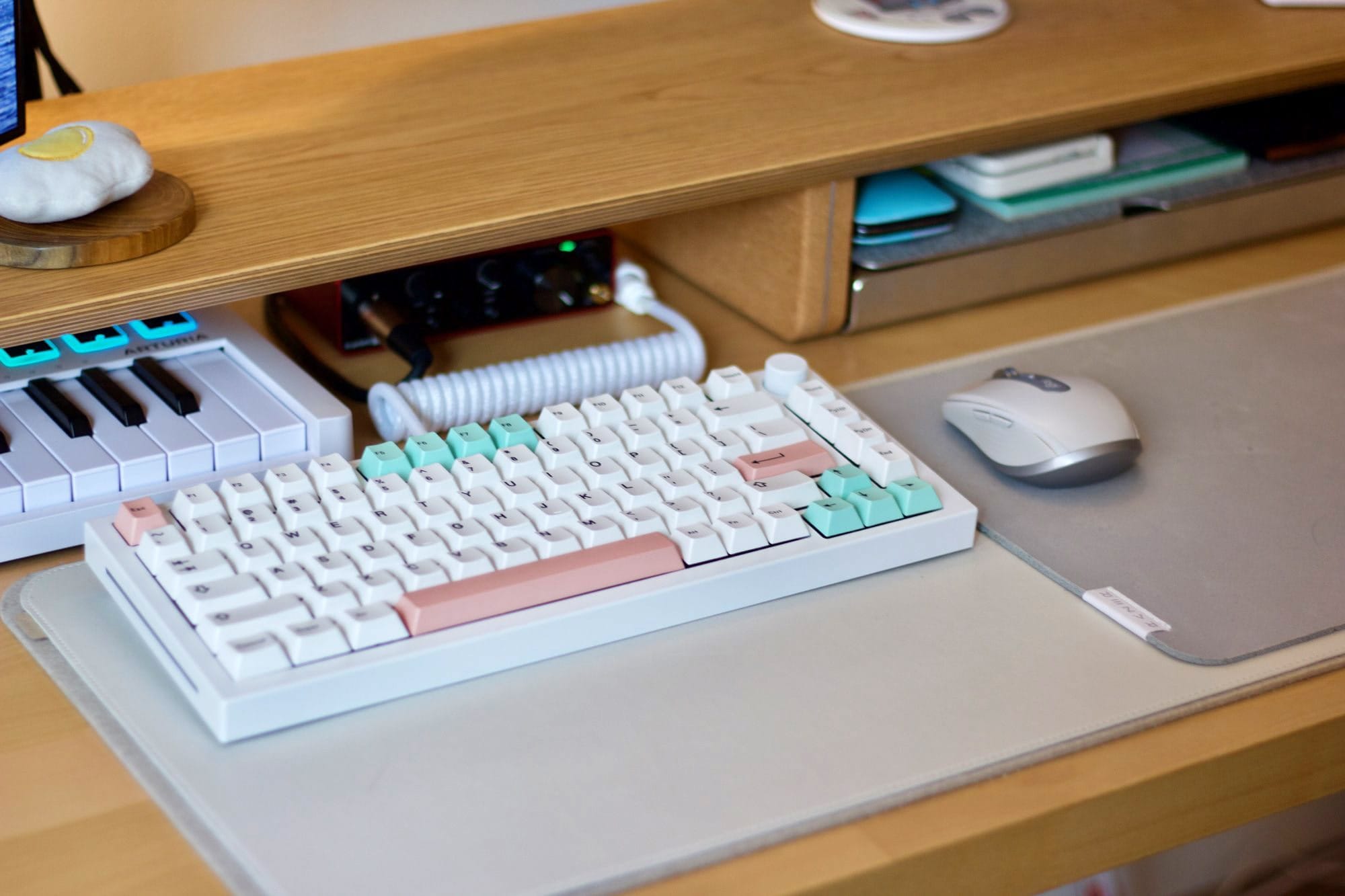 A GMMK Pro keyboard with Geekark BoW keycaps, a Logitech MX Anywhere 3 mouse, an Orbitkey desk mat, and an Arturia MiniLab 3 MIDI keyboard on a wooden desk