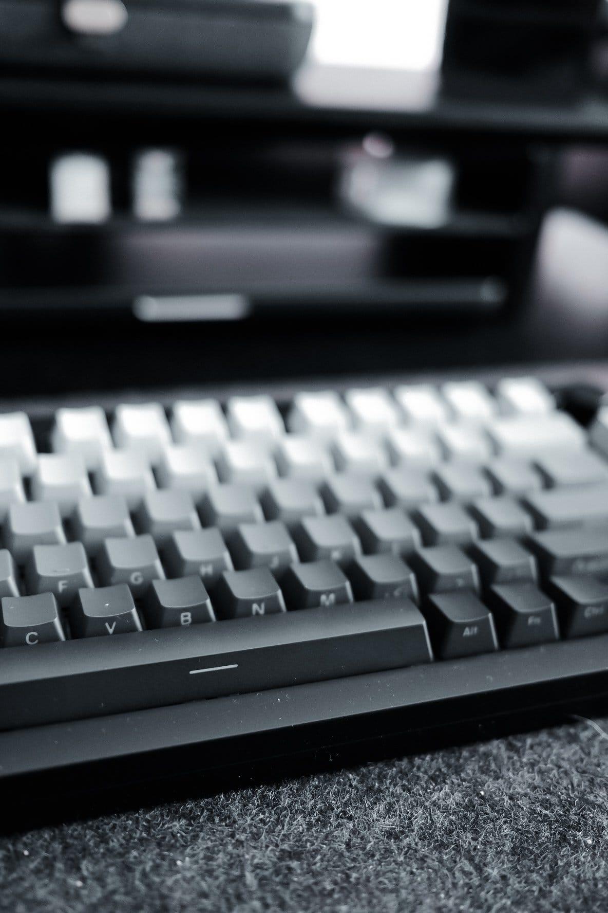 A close-up of a MonsGeek M1 keyboard with a monochrome keycap set