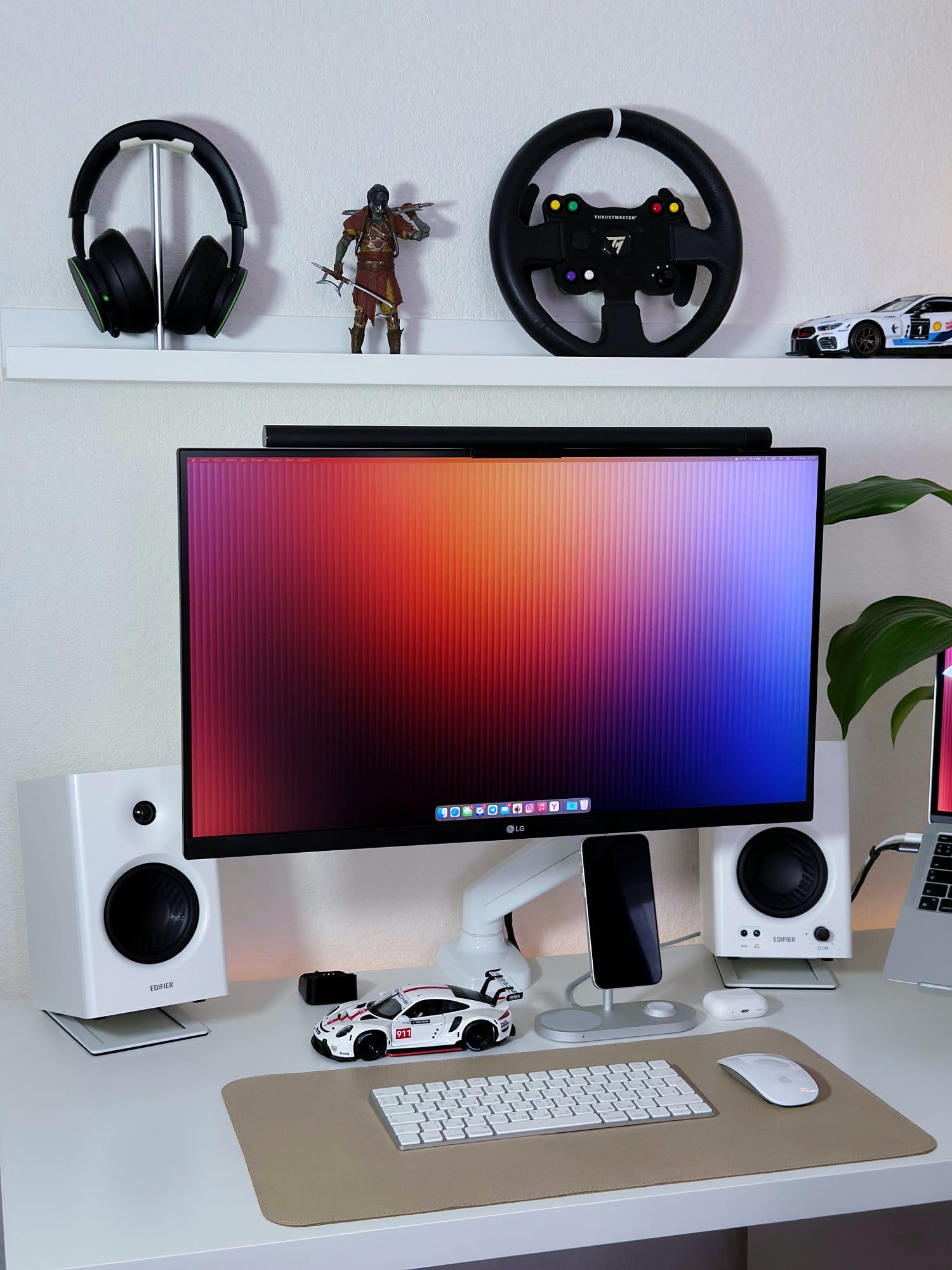 A home office setup with an LG 27UL650-W monitor, Edifier MR4 speakers, an Apple Magic Keyboard 2 and Magic Mouse 2 on a Humanmotion desk mat, and a Porsche model car on the desk